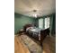 Bedroom with hardwood floors, green walls, ceiling fan, and a window with curtains at 2220 Wellington Cir, Lithonia, GA 30058
