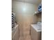A simple laundry room with white appliances, wire shelving, and basic tile flooring at 2220 Wellington Cir, Lithonia, GA 30058