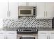 Bright kitchen features modern stainless steel appliances, subway tile backsplash, and granite countertops at 335 W Ponce De Leon Ave # 506, Decatur, GA 30030