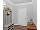 Charming entryway features a gray hall tree bench, dark wood-look floors and a white door at 485 Crescent Woode Dr, Dallas, GA 30157