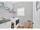 Bright laundry room with white washer, dryer, storage shelves, and a window at 485 Crescent Woode Dr, Dallas, GA 30157