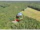 Aerial shot of a home surrounded by lush greenery with a neighboring open field at 718 Fincher Rd, Covington, GA 30016