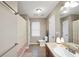 Bright bathroom featuring double sinks, lots of storage, and a walk-in shower behind a curtain at 718 Fincher Rd, Covington, GA 30016