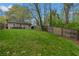 This backyard includes a green lawn, a wooden fence, and a small patio with an outdoor seating area at 1963 Main Nw St, Atlanta, GA 30318
