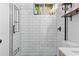 Modern bathroom featuring a glass-enclosed shower with white subway tile and a floating wood shelf at 1963 Main Nw St, Atlanta, GA 30318