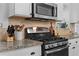 Close-up of a modern gas range stove in a bright kitchen with granite countertops at 1963 Main Nw St, Atlanta, GA 30318