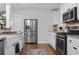 Spacious kitchen features stainless steel appliances, farmhouse sink, and white cabinets and hardwood floors at 1963 Main Nw St, Atlanta, GA 30318
