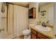 Clean bathroom with a shower-tub combo and wooden cabinet at 240 Arthurs Ln, Covington, GA 30016