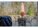 Outdoor deck area featuring table, umbrella, and chairs overlooking a wooded lot at 240 Arthurs Ln, Covington, GA 30016