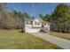 Charming home featuring a 2-car garage, landscaped yard, and a welcoming staircase leading to the front door at 240 Arthurs Ln, Covington, GA 30016
