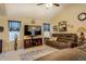 Cozy living room featuring a large TV, ceiling fan, and a comfortable brown leather sofa at 240 Arthurs Ln, Covington, GA 30016