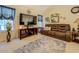 Comfortable living room featuring a large TV, ceiling fan, and brown leather sofa at 240 Arthurs Ln, Covington, GA 30016