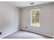 Cozy bedroom with a gray carpet and walls, featuring a window for natural light at 4558 Dorsett Shoals Ct, Douglasville, GA 30135