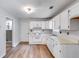 Bright kitchen featuring white cabinets, wood floor, gas stove, and double bowl stainless steel sink at 4558 Dorsett Shoals Ct, Douglasville, GA 30135