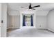 Spacious main bedroom with a ceiling fan, and a large window with blue curtains at 4558 Dorsett Shoals Ct, Douglasville, GA 30135