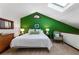 Bright bedroom features a green accent wall, a comfortable queen bed, and a skylight, creating a cheerful and serene retreat at 131 Cypress St, Roswell, GA 30075