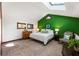 Bright bedroom with a skylight, green accent wall, and comfortable furnishings, creating a cozy and inviting atmosphere at 131 Cypress St, Roswell, GA 30075