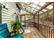 Relaxing sunroom with a screened enclosure, wooden floor and ceiling, a ceiling fan, and comfortable blue chairs at 131 Cypress St, Roswell, GA 30075
