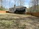 View of the home from backyard, featuring a wooden fence, deck, and lush greenery at 1380 Cedar Hl, Douglasville, GA 30134