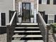 Close-up of the front porch with a black front door, decorative plants, and a 'Welcome' sign at 1380 Cedar Hl, Douglasville, GA 30134