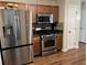 Modern kitchen features stainless steel appliances, wood cabinets, and a functional layout for cooking and storage at 1380 Cedar Hl, Douglasville, GA 30134