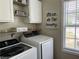 Functional laundry room with modern appliances, overhead cabinets and shelves for storage at 1380 Cedar Hl, Douglasville, GA 30134