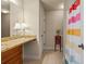 A bathroom featuring tiled floors, granite countertop vanity and a colorful shower curtain at 1526 Rocky River Dr, Lawrenceville, GA 30045