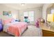 Bedroom featuring tan carpet, neutral walls, a desk, and pink bedspread at 1526 Rocky River Dr, Lawrenceville, GA 30045