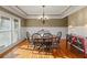 Sunlit dining room showcasing hardwood floors, large windows, and wainscoting at 1526 Rocky River Dr, Lawrenceville, GA 30045