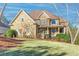 Two-story home featuring a stone and brick facade, covered front porch, and well-maintained landscaping at 1526 Rocky River Dr, Lawrenceville, GA 30045