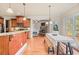 Open concept kitchen and dining area with stone fireplace, stainless appliances, and hardwood floors at 1526 Rocky River Dr, Lawrenceville, GA 30045