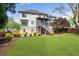 Expansive backyard featuring lush lawn, mature landscaping, and a charming wooden deck with stairs at 5081 Stone Moss Way, Hoschton, GA 30548