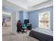 A bedroom with blue walls, carpet floors, and a window with blinds at 5081 Stone Moss Way, Hoschton, GA 30548