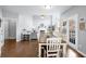 Open-concept dining area flows into a living room, featuring hardwood floors and lots of natural light at 5081 Stone Moss Way, Hoschton, GA 30548