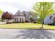 A beautifully landscaped two-story brick home with mature trees at 5081 Stone Moss Way, Hoschton, GA 30548