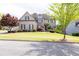 Stately brick home with manicured lawn, mature trees, and a well-maintained garden at 5081 Stone Moss Way, Hoschton, GA 30548