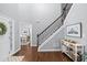 Elegant foyer with hardwood floors, staircase with dark wood railings, and a glimpse into the office at 5081 Stone Moss Way, Hoschton, GA 30548