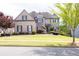 Inviting brick home boasts a manicured lawn, beautiful landscaping, and charming architectural details at 5081 Stone Moss Way, Hoschton, GA 30548