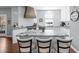 Bright kitchen boasts gray cabinets, granite countertops, backsplash, stainless appliances, and spacious island at 5081 Stone Moss Way, Hoschton, GA 30548