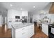 Bright kitchen features an island with granite countertops, white cabinetry, and stainless appliances at 5081 Stone Moss Way, Hoschton, GA 30548