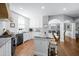Bright kitchen features white cabinets, granite countertops, stainless appliances, and a spacious center island at 5081 Stone Moss Way, Hoschton, GA 30548