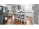 Bright kitchen features a large island with bar seating, white cabinets, and hardwood floors at 5081 Stone Moss Way, Hoschton, GA 30548