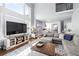 Bright open floor plan, large TV, hardwood floors, and a large sectional couch at 5081 Stone Moss Way, Hoschton, GA 30548