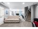 Open-concept living area with plush sofa, recessed lighting, and stairs leading to another level at 5081 Stone Moss Way, Hoschton, GA 30548