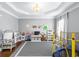 Spacious playroom with gray walls, large window, and ample space for activities and learning at 5081 Stone Moss Way, Hoschton, GA 30548