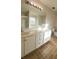 Bathroom with a large mirror, dual sinks, and a tiled floor, offering ample counter space at 771 Franklin Mill Trce, Loganville, GA 30052