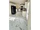 Bright kitchen featuring white cabinets, stainless steel appliances, and stylish white marble-patterned flooring at 771 Franklin Mill Trce, Loganville, GA 30052