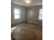 Bedroom with wood-look paneling, hardwood floors, and natural light from the windows at 1253 Gus Thornhill Jr Dr, Atlanta, GA 30344