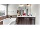 Bathroom featuring double sinks, soaking tub, tile flooring and modern lighting at 1332 Worcester Trl, Mcdonough, GA 30253
