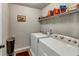 Laundry room featuring a washer, dryer, wire shelving and vinyl flooring at 1332 Worcester Trl, Mcdonough, GA 30253